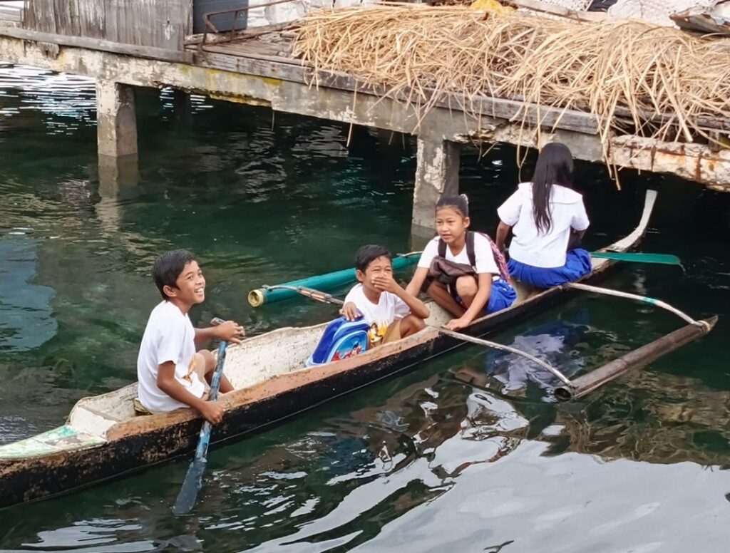 Badjao sea gypsy tribe children commute to coastal schools in canoes.